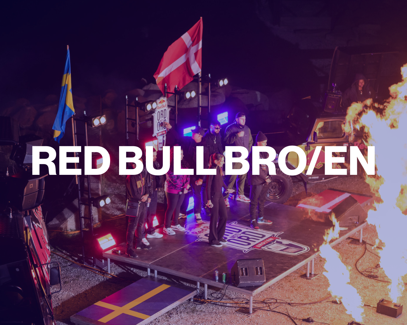 People on stage at a Red Bull event with flags, flames, and stage lights, promoting the Red Bull OBR race.