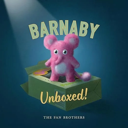 Book cover for 'Barnaby Unboxed!'. Created by The Fan Brothers. Pink plush toy mouse with big eyes, standing inside a green box with yellow and purple accents, set against a blue background. 
