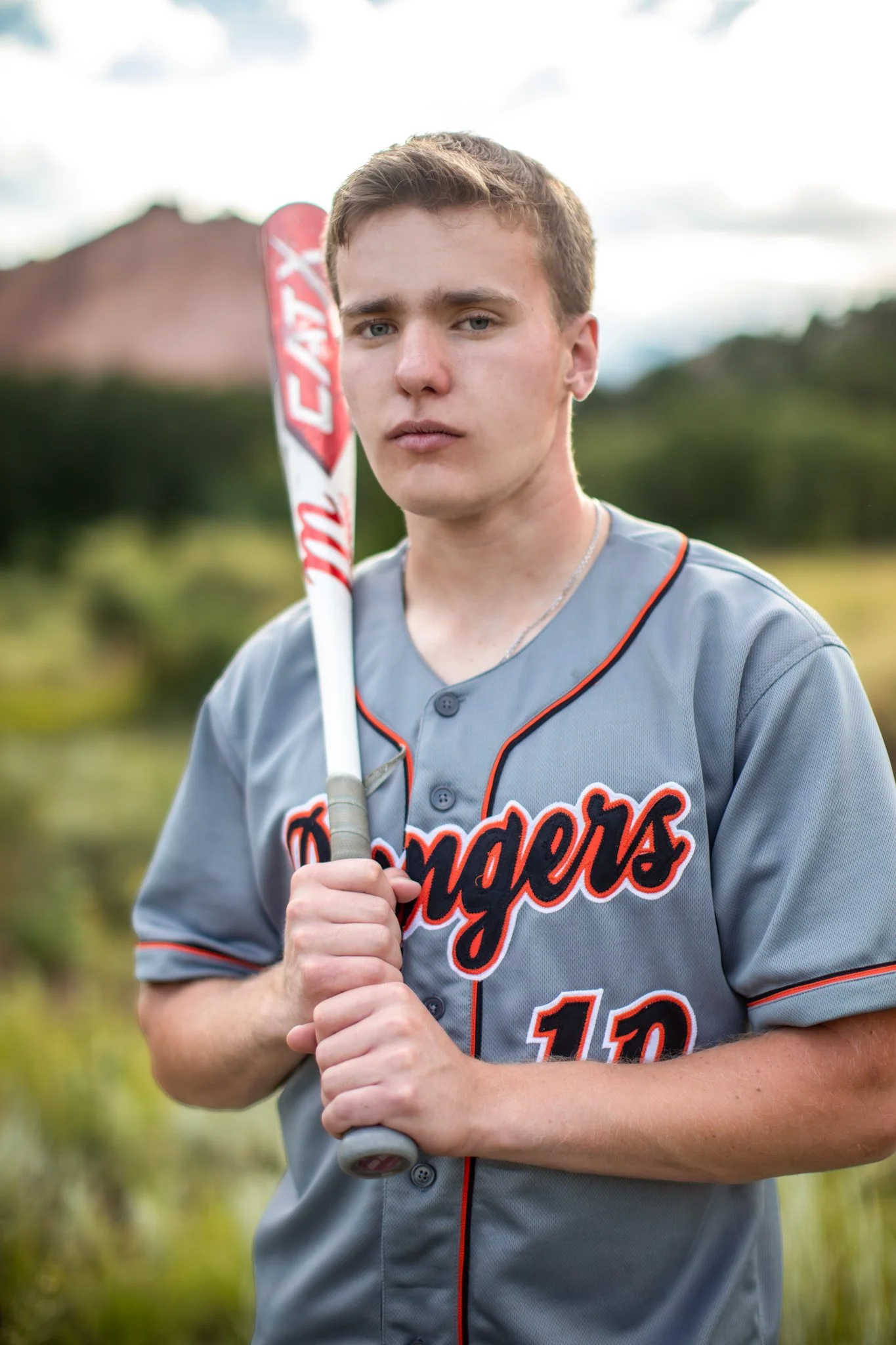 Colorado Springs High School Senior Portrait Photographer captures portrait of young man with his baseball bat the Garden of the Gods in the background.