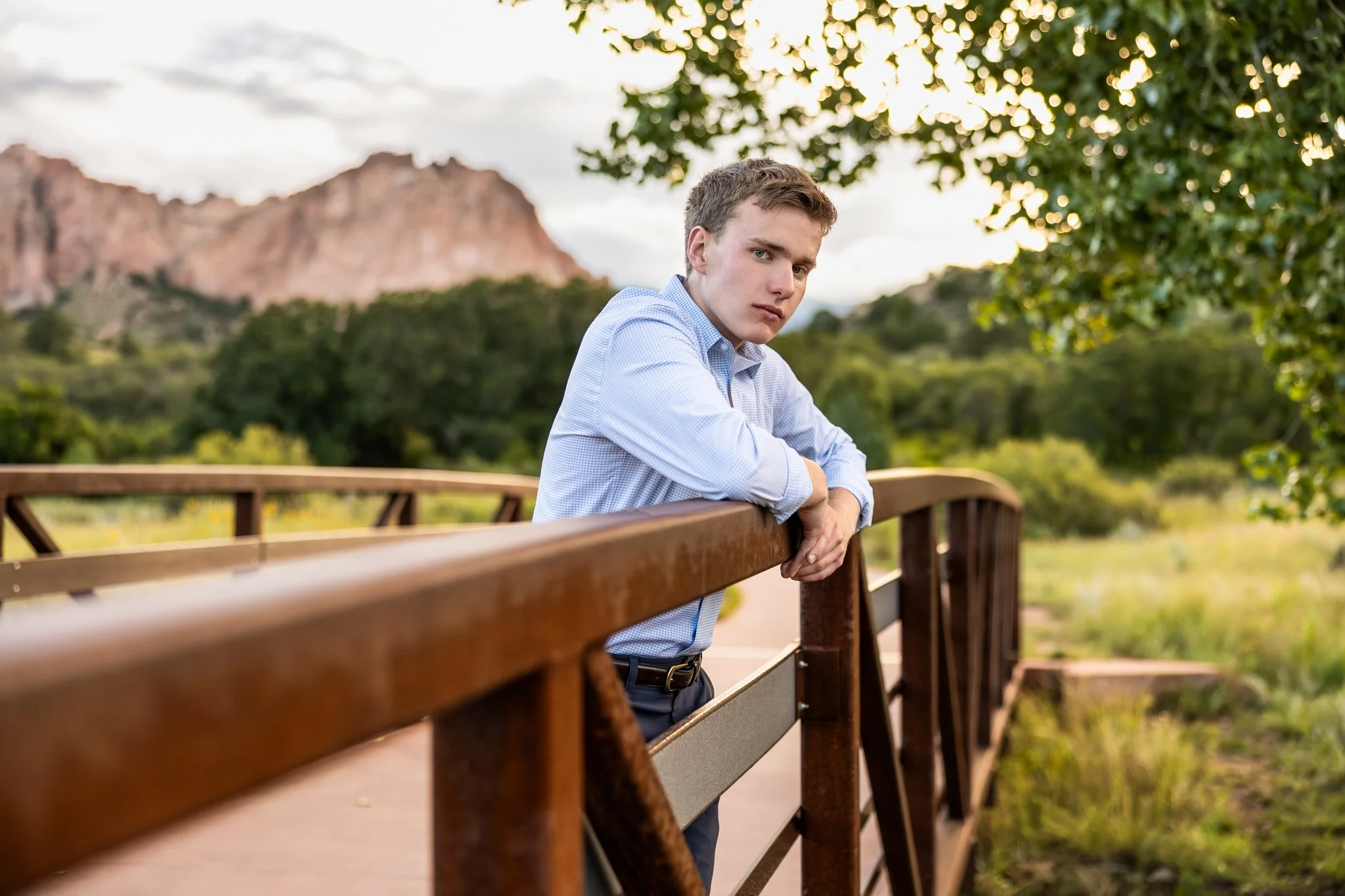 Colorado Springs Senior Photographer takes picture of boy on bridge with Garden of the Gods in the background.