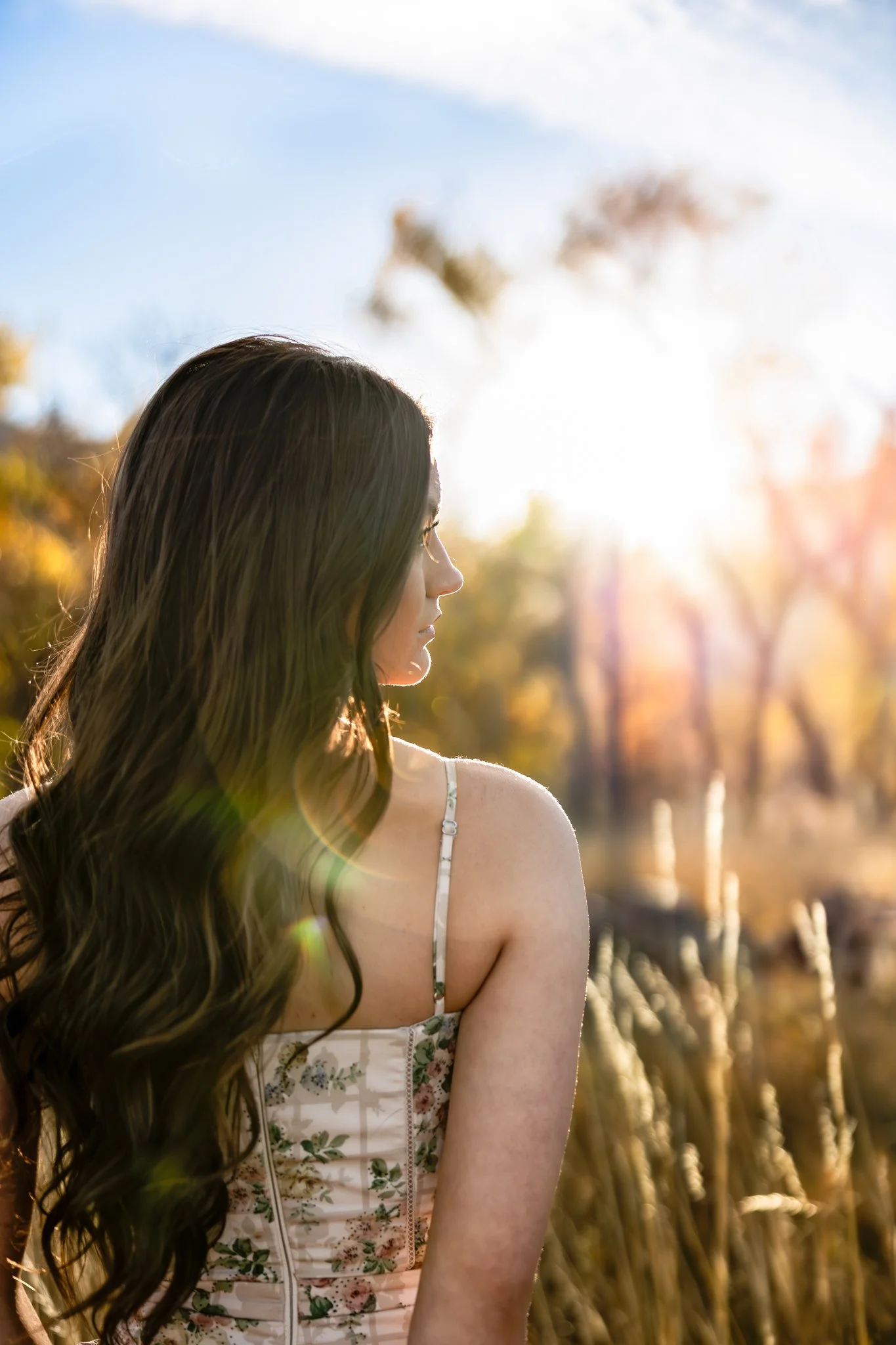 Denver Colorado Senior Photographer takes portrait of high school senior girl standing in field of tall grass.