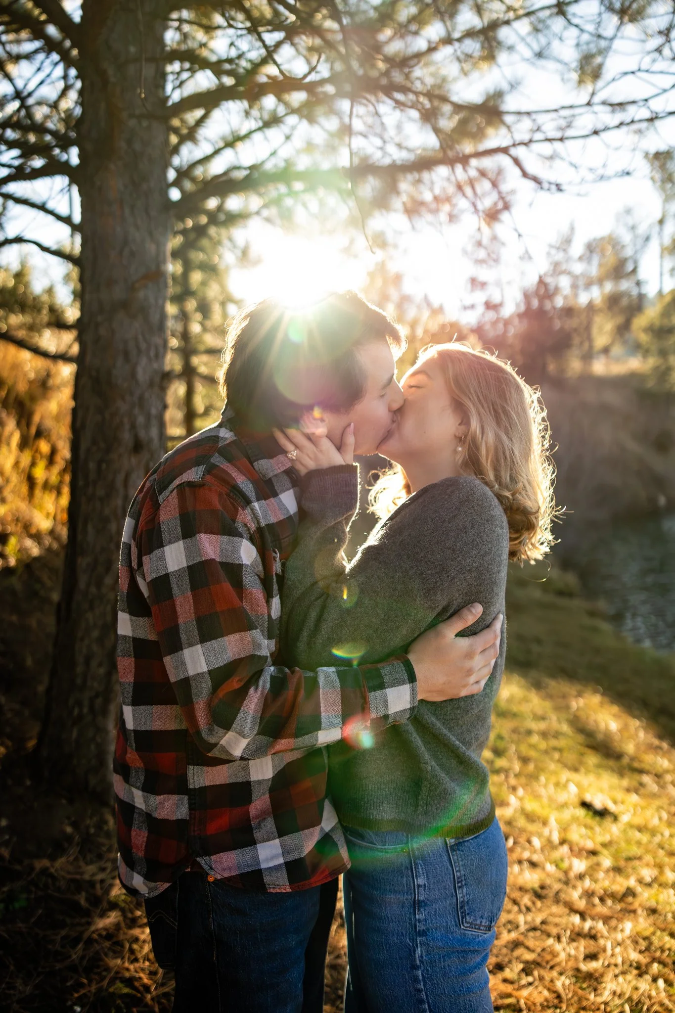 Couple kissing with sun streaming in from behind them Photo taken by Kim Graves Photography