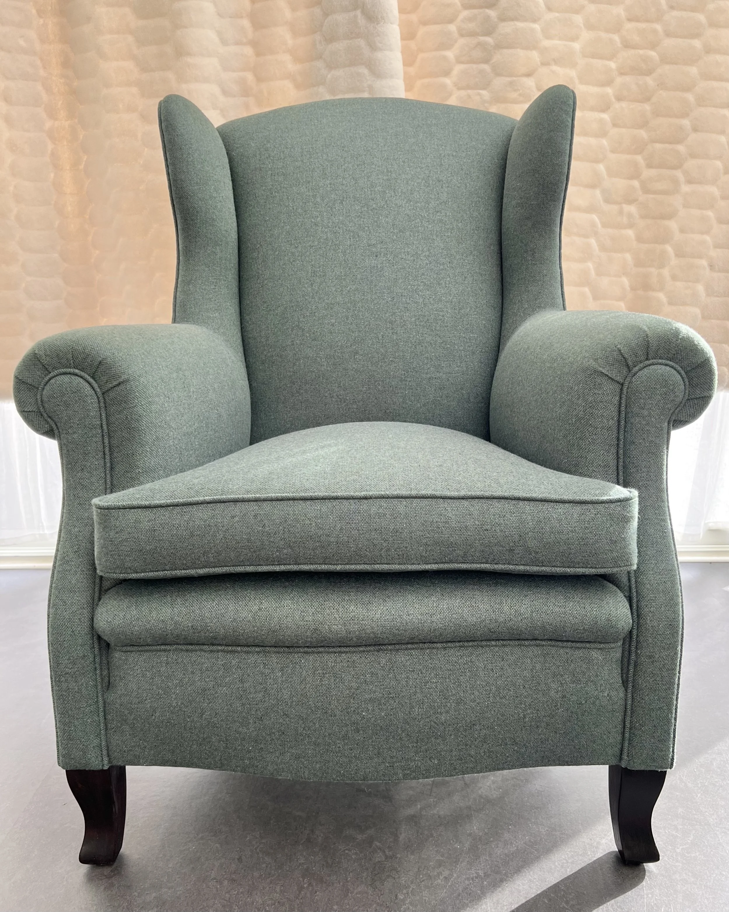 Öronlappsfåtölj 20/30-tal från Oskar Bernströms Möbelfarik totalrenoverad. Klädd i Main Line Flax från Camira. Benen har fått ny bets.