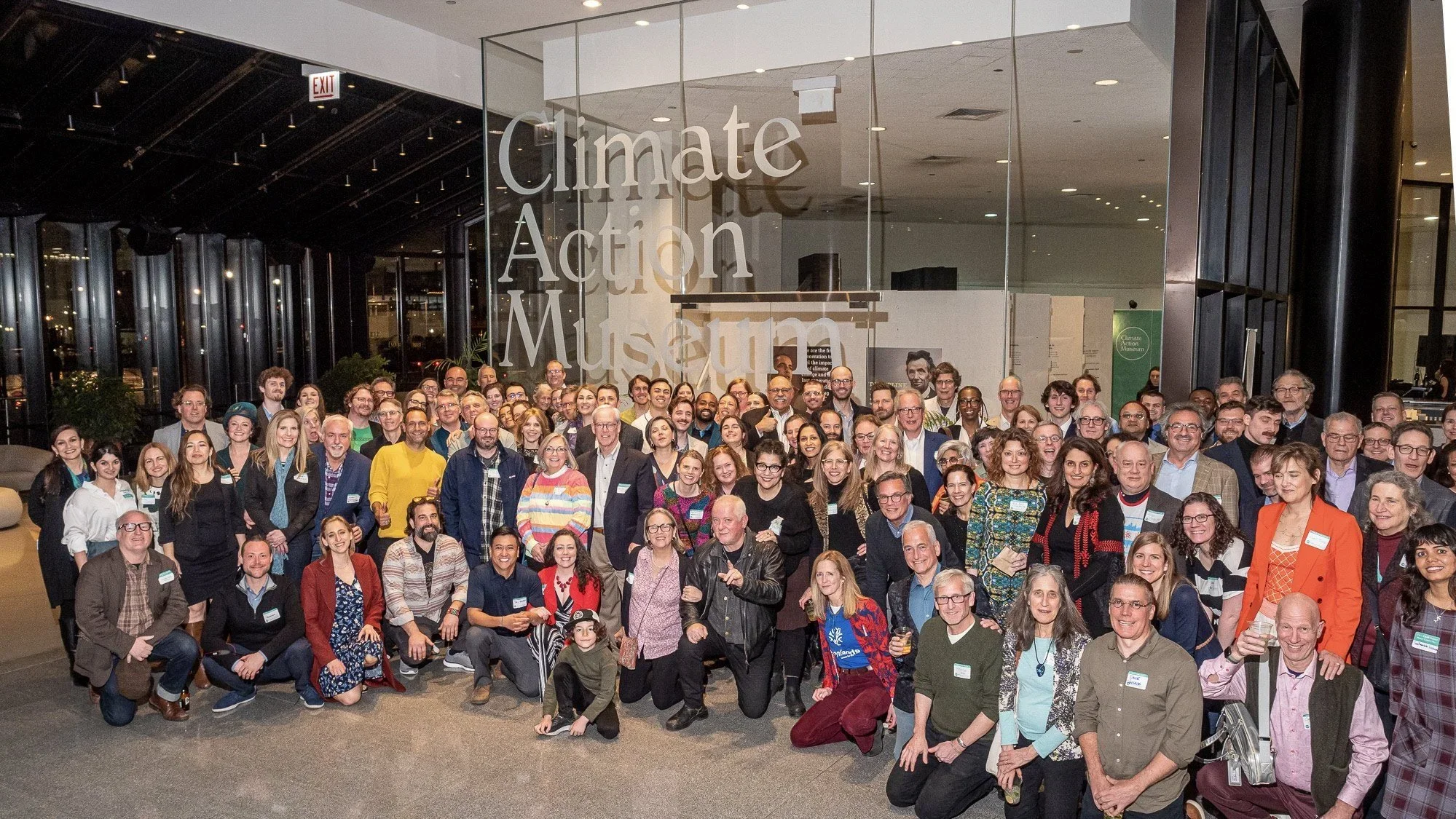 A large group of people pose in front of the Climate Action Museum