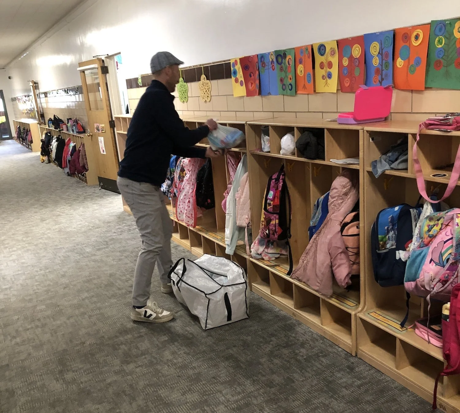 A TNB volunteer places an Essentials Pantry order in a child's cubby for easy pick up.