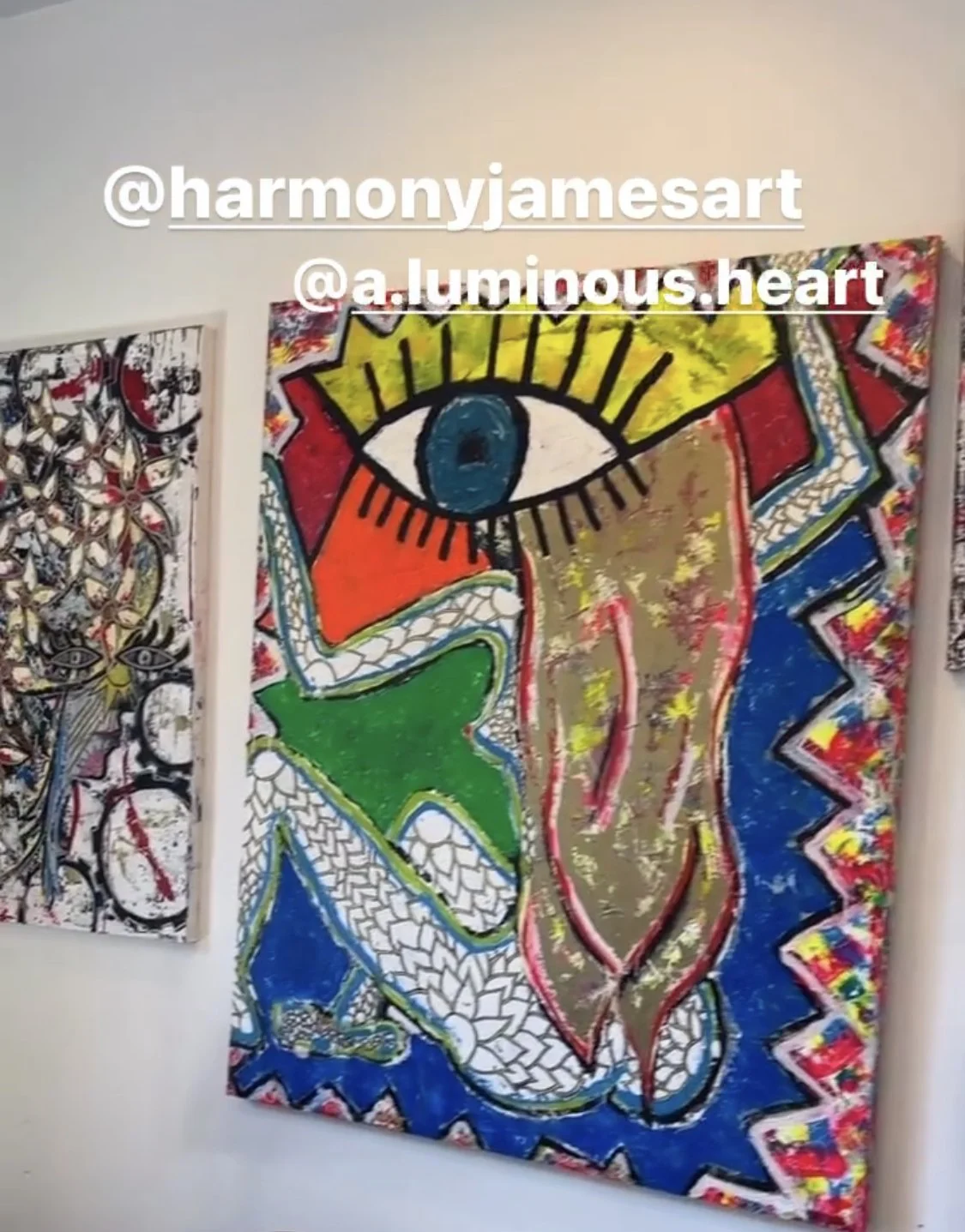Colorful abstract artwork featuring a large face with a blue eye, yellow hair, and a serpent-like body against a vibrant background with red, green, blue, and gold elements.