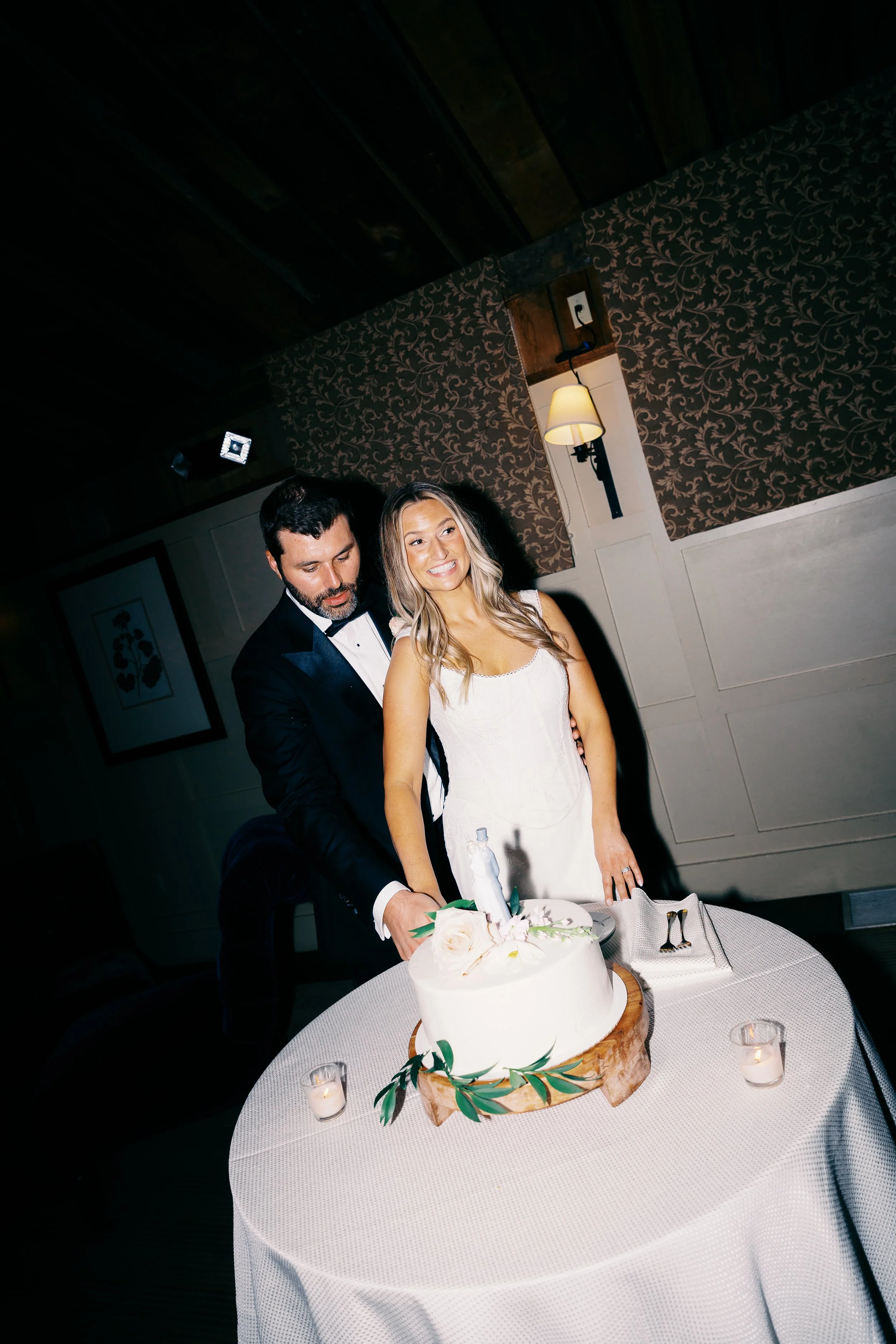 A bride and groom cutting a wedding cake at their reception.
