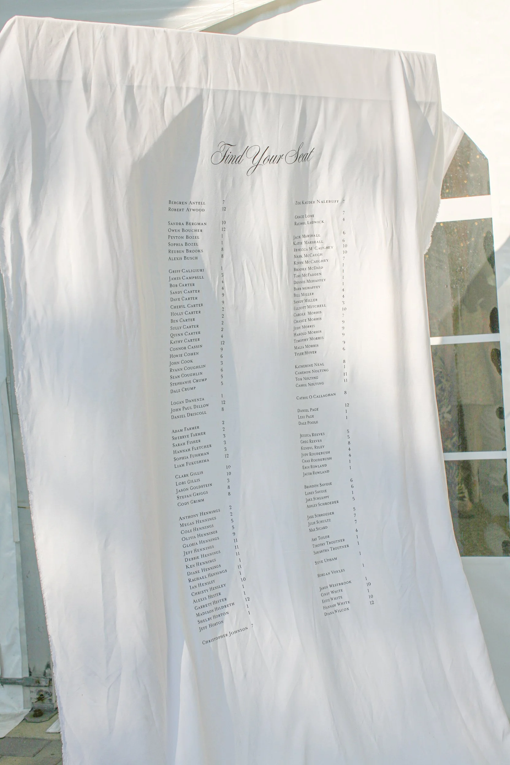 Seating chart with the heading "Find Your Seat" for an event, listing names of guests and their seat numbers.