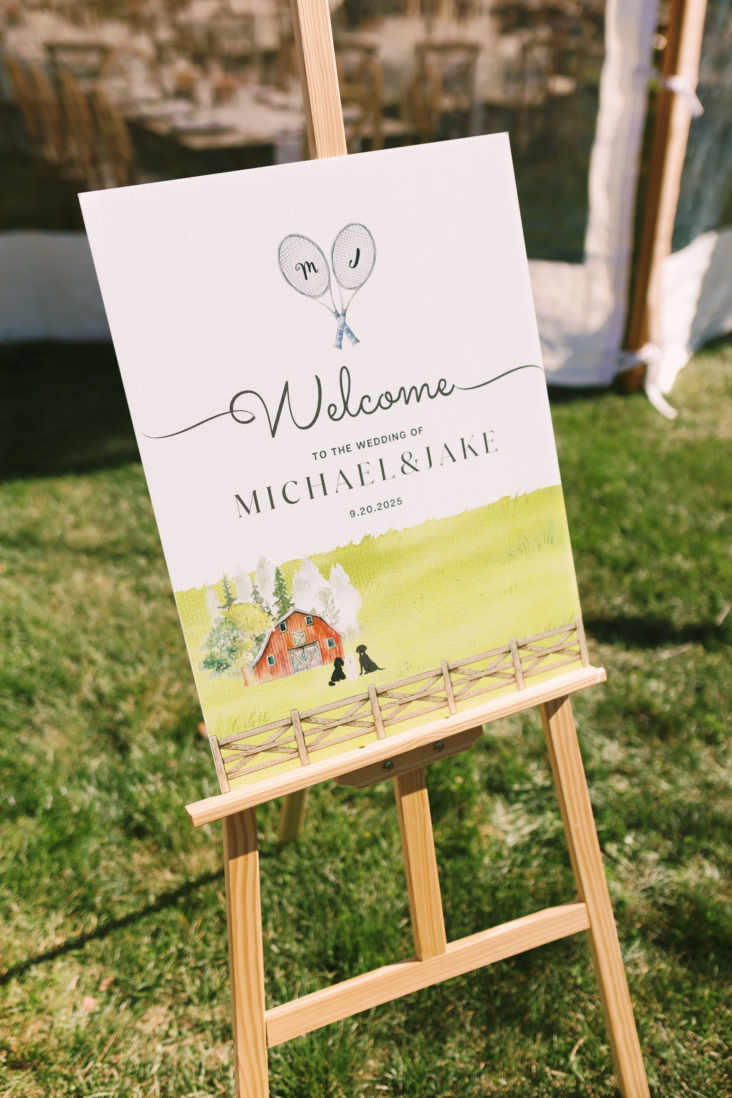Welcome sign at a wedding for Michael and Jake on September 20, 2025, featuring a cow painting, a barn, and a fence.