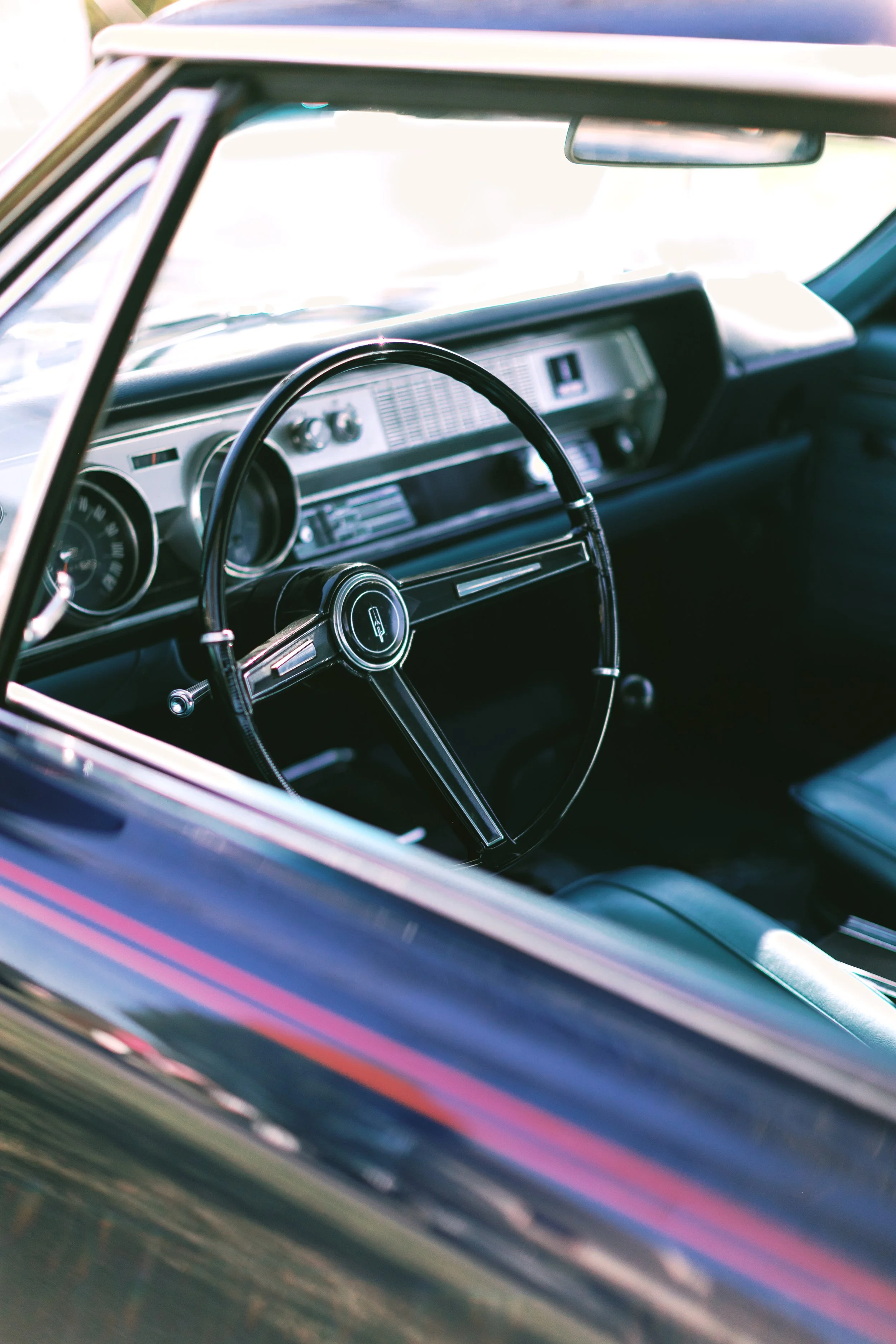 Interior of a vintage car showing a classic steering wheel and dashboard.