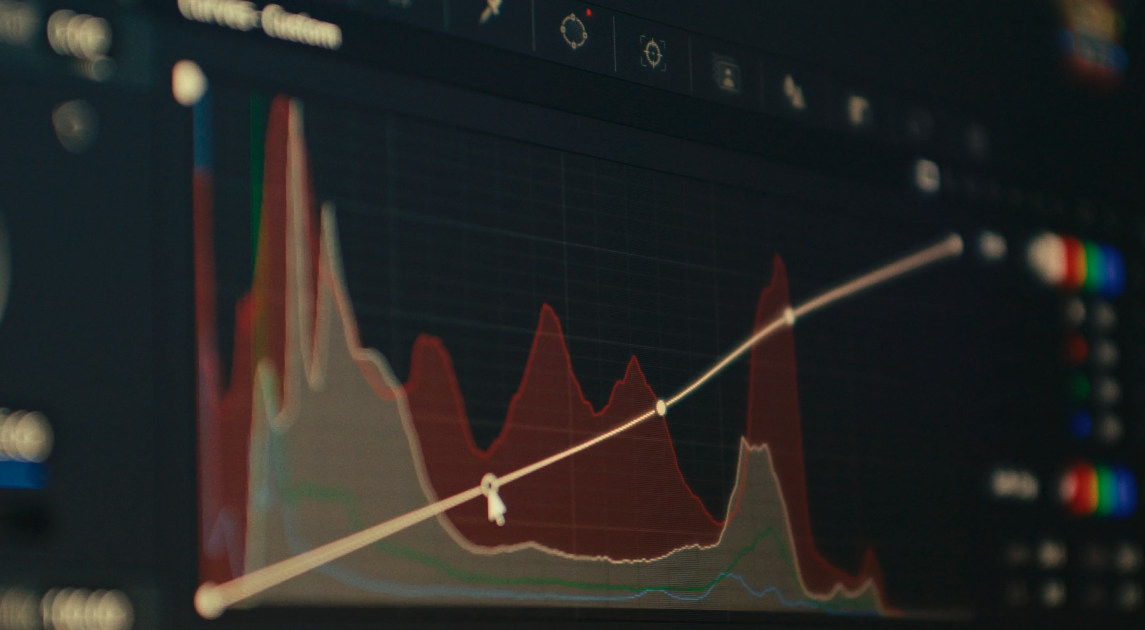 Close-up of a computer screen displaying a line graph and colorful data visualizations, likely related to financial or scientific analysis.