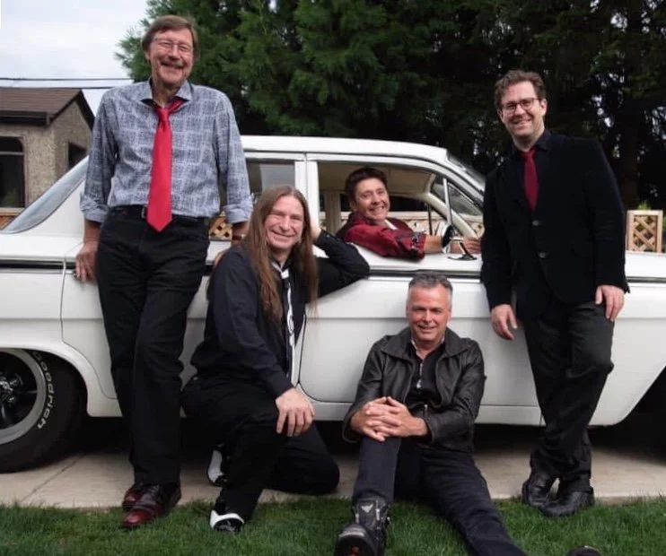 Neon sign reading 'Maxwell Smart' in cursive letters on a dark background.