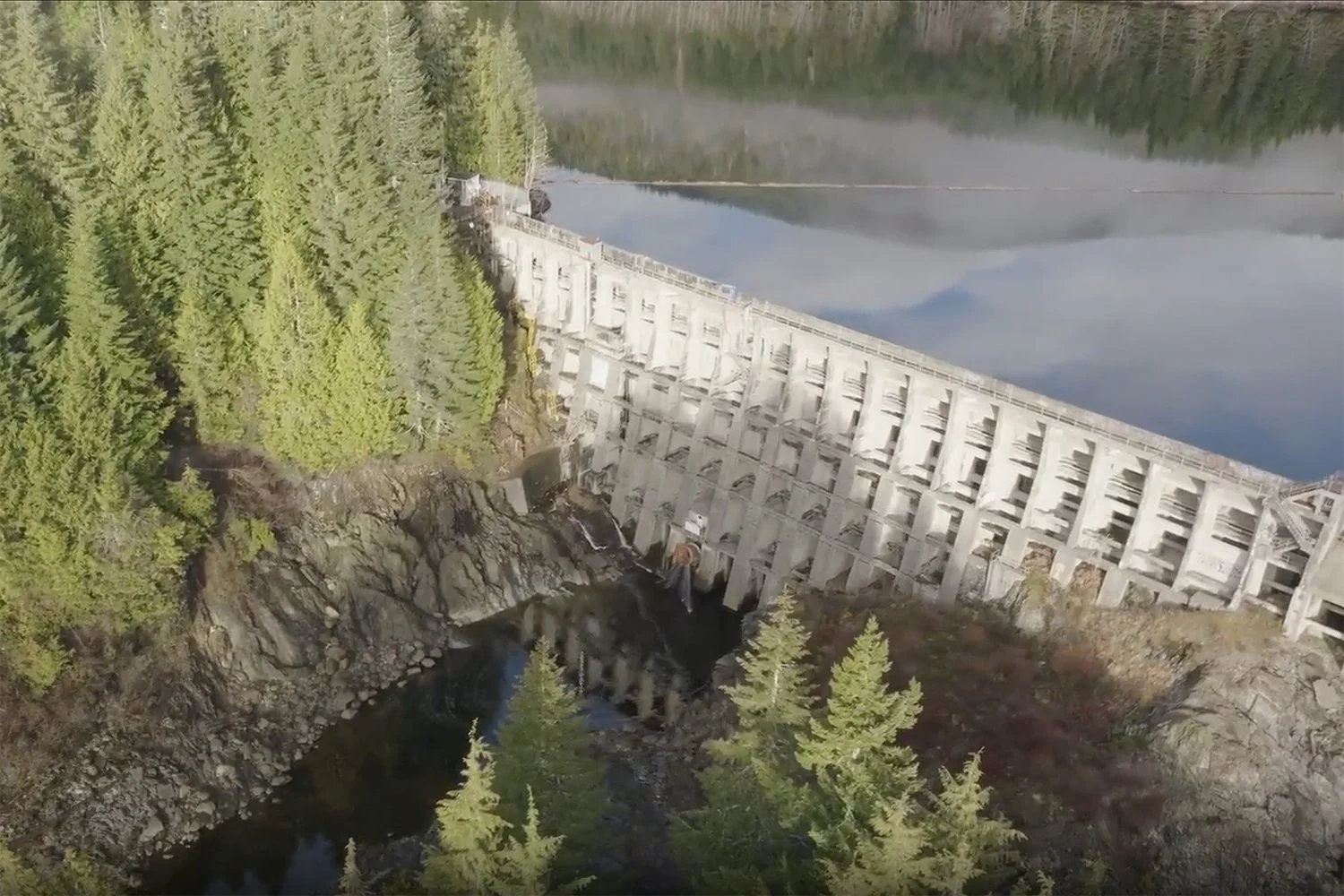 an aerial image of the diversion dam showing the reservoir against the concrete structure of the dam and river below