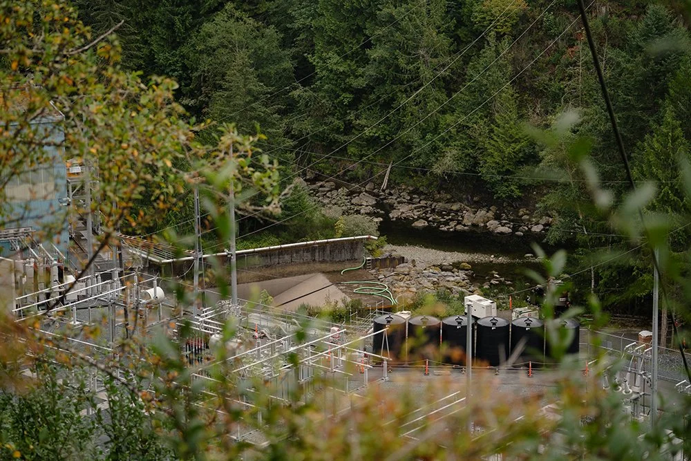 The mainstream spawning channel below the Elliott Dam Powerhouse, narrow river beside industrial activity.