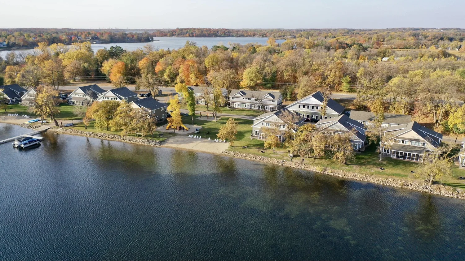 Aerial view of Lake Darling Resort villas along the shoreline surrounded by orange and gold autumn canopy