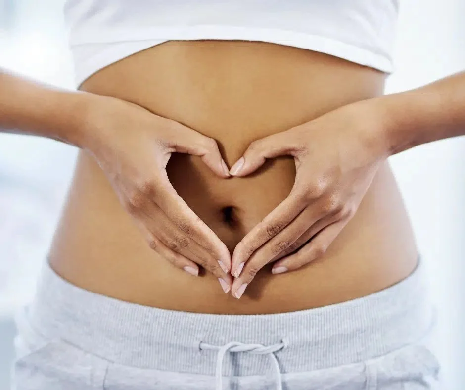 Woman holding her abdomen representing digestive health