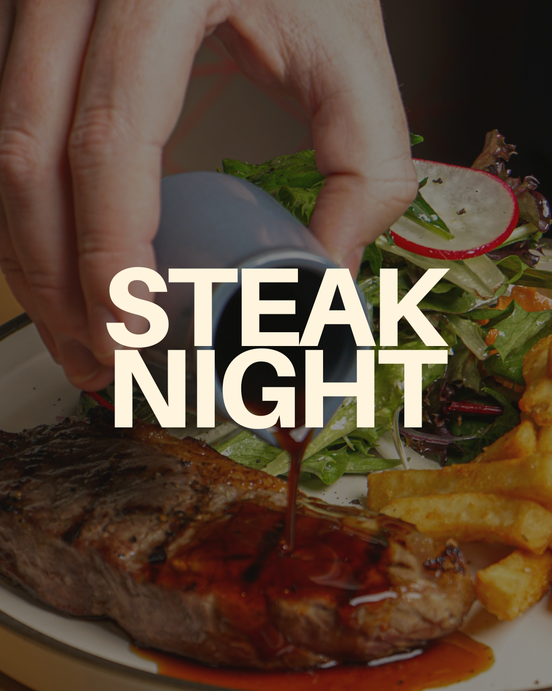 Hand pouring steak sauce over a grilled steak alongside a side salad and fries on a plate with the text 'Steak Night'