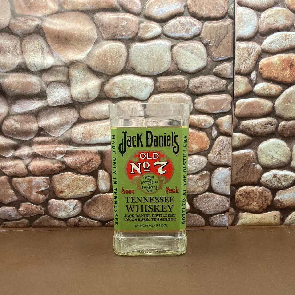 Jack Daniel's Old Number 7 Bottle Sour Mash Green Candle. Comes with a custom wood wick. The Palm Tree wax gives it a distinct look the wood wick makes it crackle. Natural fragrance oils.