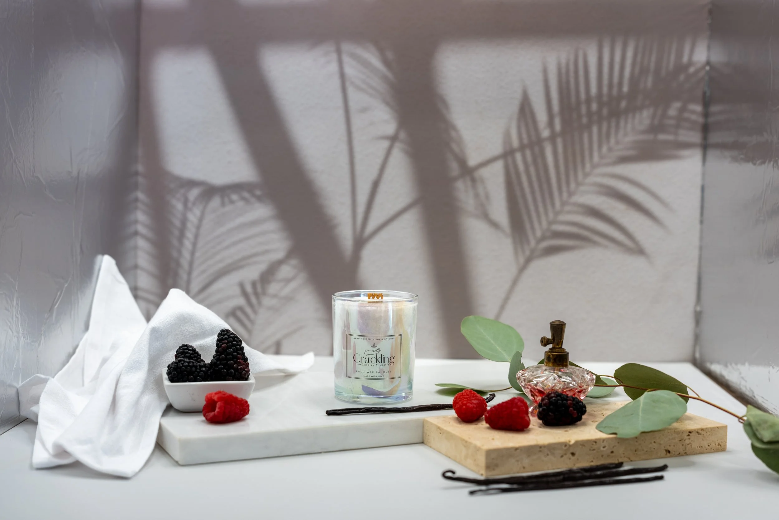 Hand-poured Black Raspberry & Vanilla candle styled with raspberries, blackberries, vanilla beans, eucalyptus, and white linen.