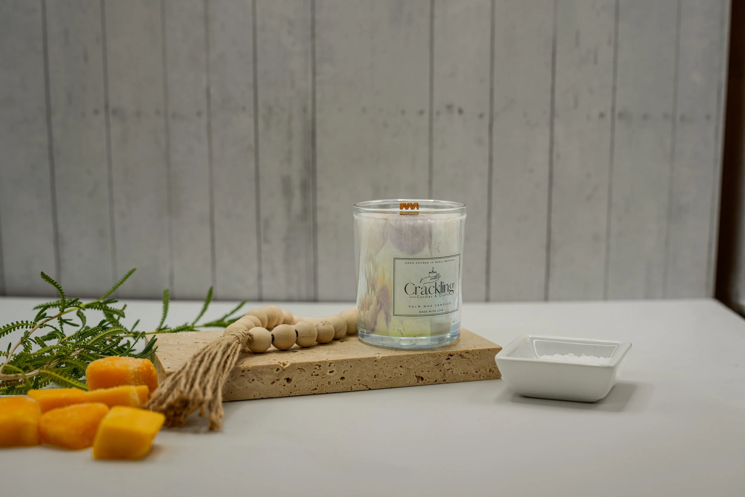 Island Mango candle on a wooden board with mango pieces and a small white dish