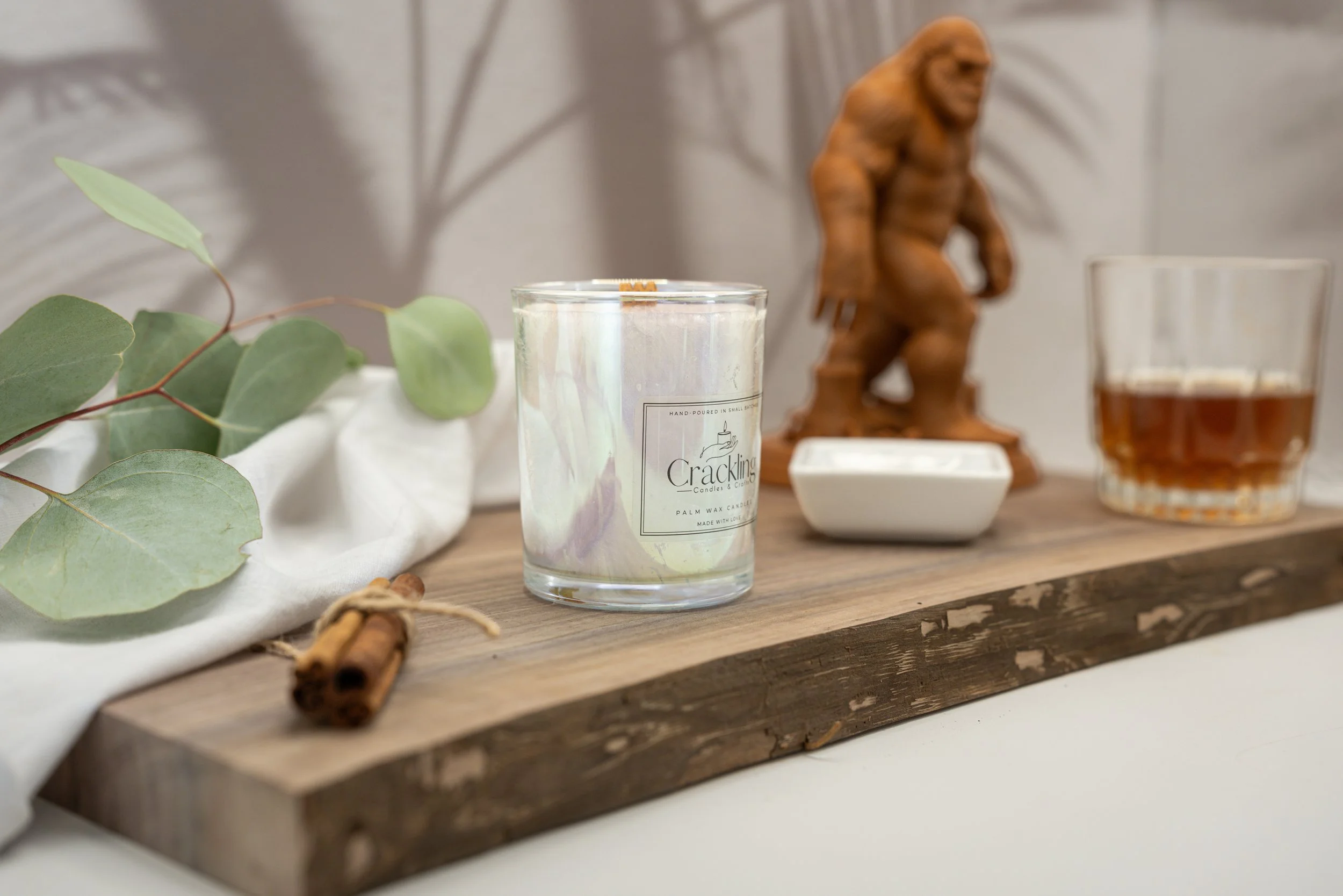 6 oz South Bourbon Whisky palm wax candle with a wooden wick displayed on a rustic wood board