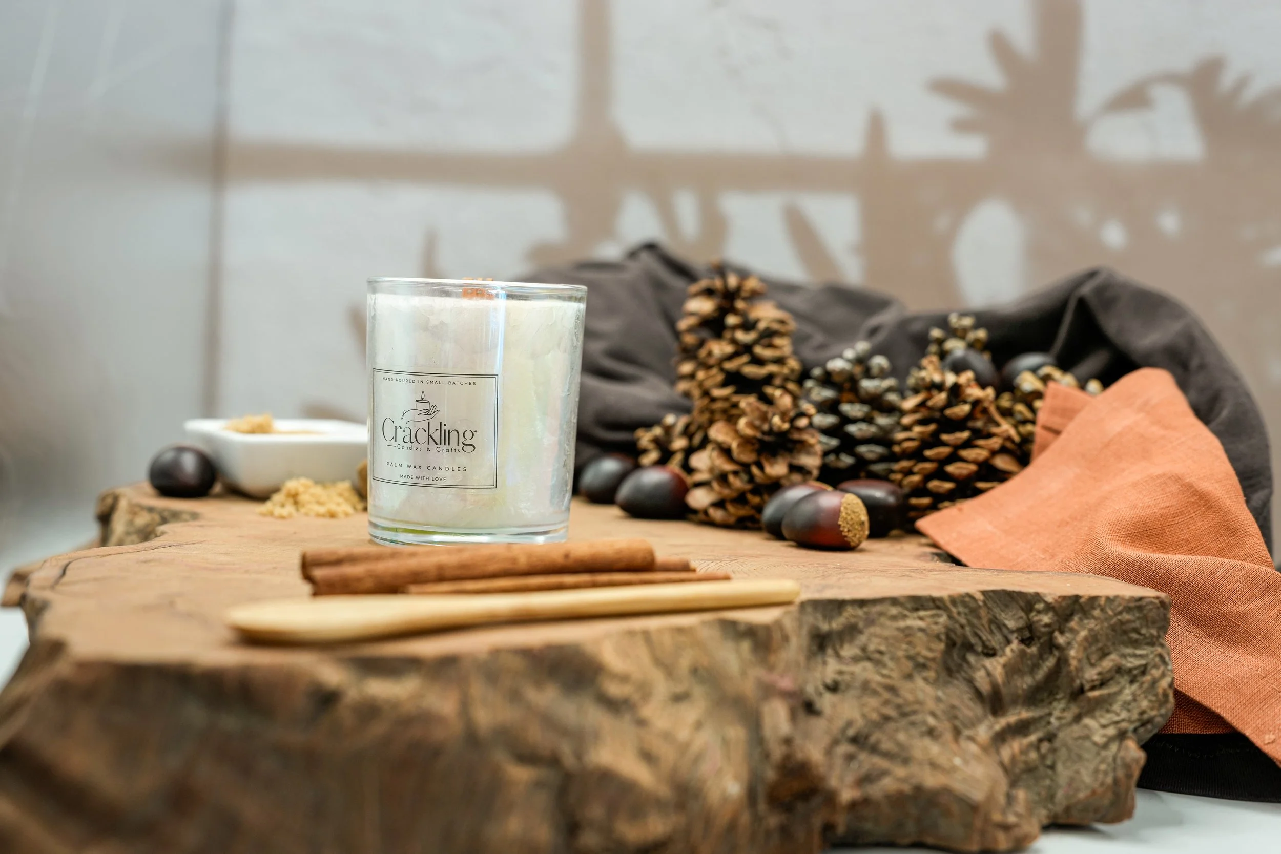 Chestnuts & Brown Sugar candle displayed on a rustic wood slab with pinecones, cinnamon sticks, chestnuts, and warm fall decor.