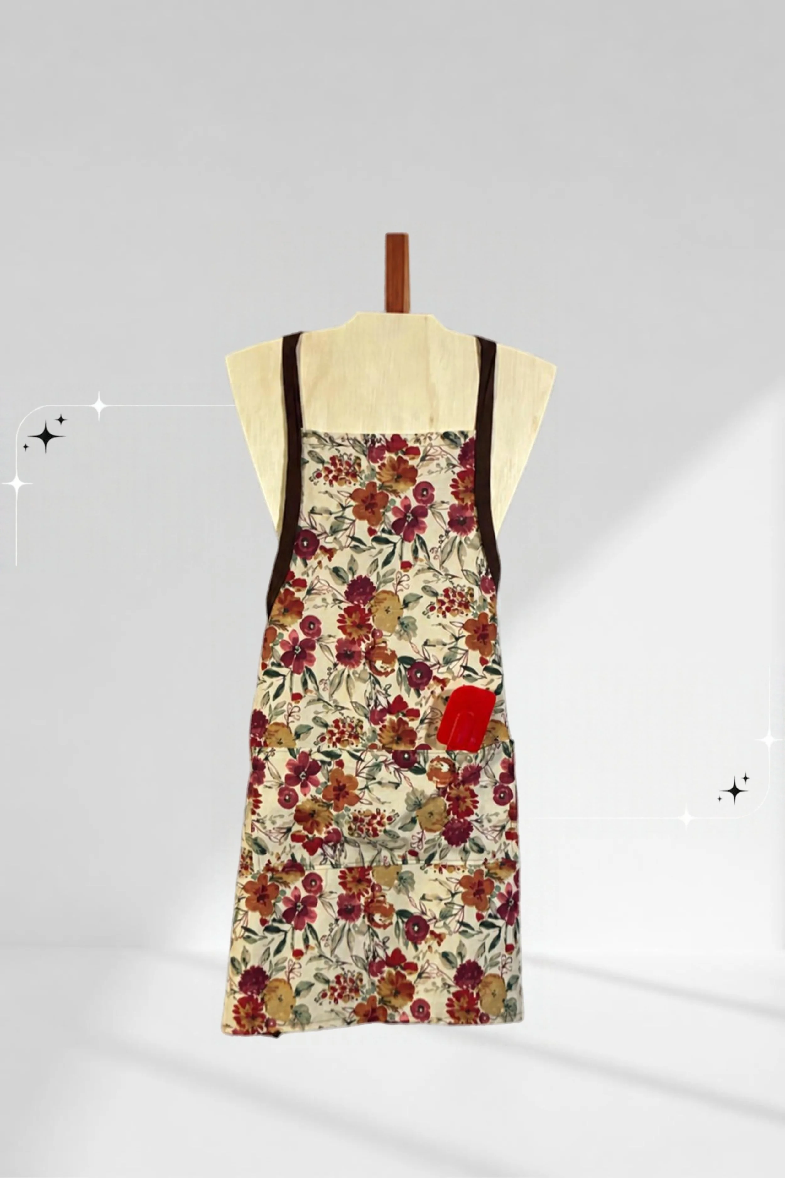 Handmade fall floral apron with brown straps and a front pocket, displayed on a wooden torso.