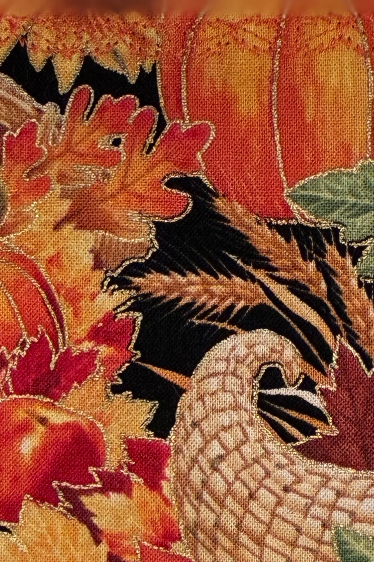Close-up of harvest-print cotton fabric featuring pumpkins, autumn leaves, wheat, and a woven cornucopia.
