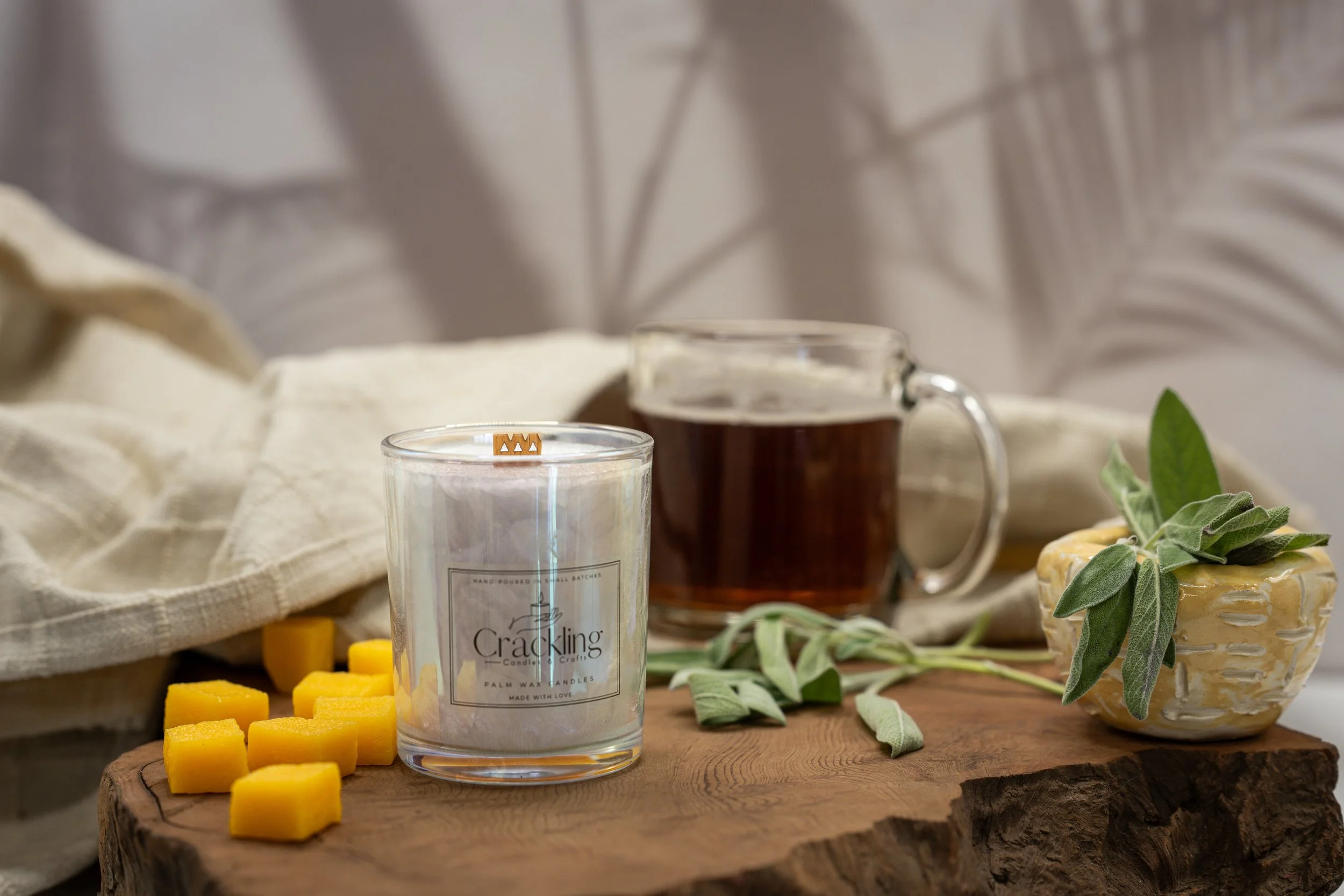 Mango Papaya candle in a clear glass jar, with a wooden wick, styled beside diced mango and a glass mug.