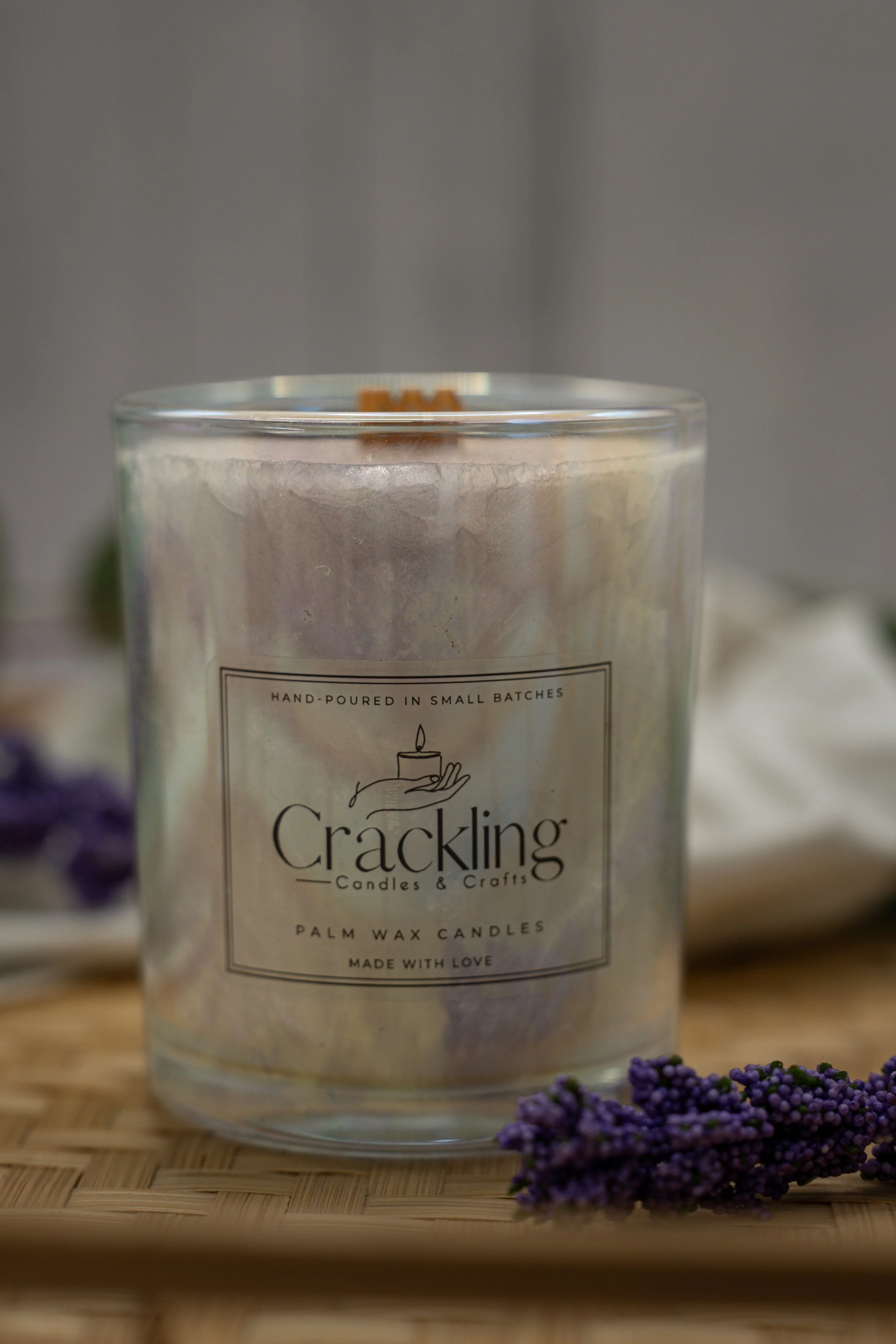 Close-up of a palm wax candle showing its wooden wick, textured wax, and Crackling Candles & Crafts label.