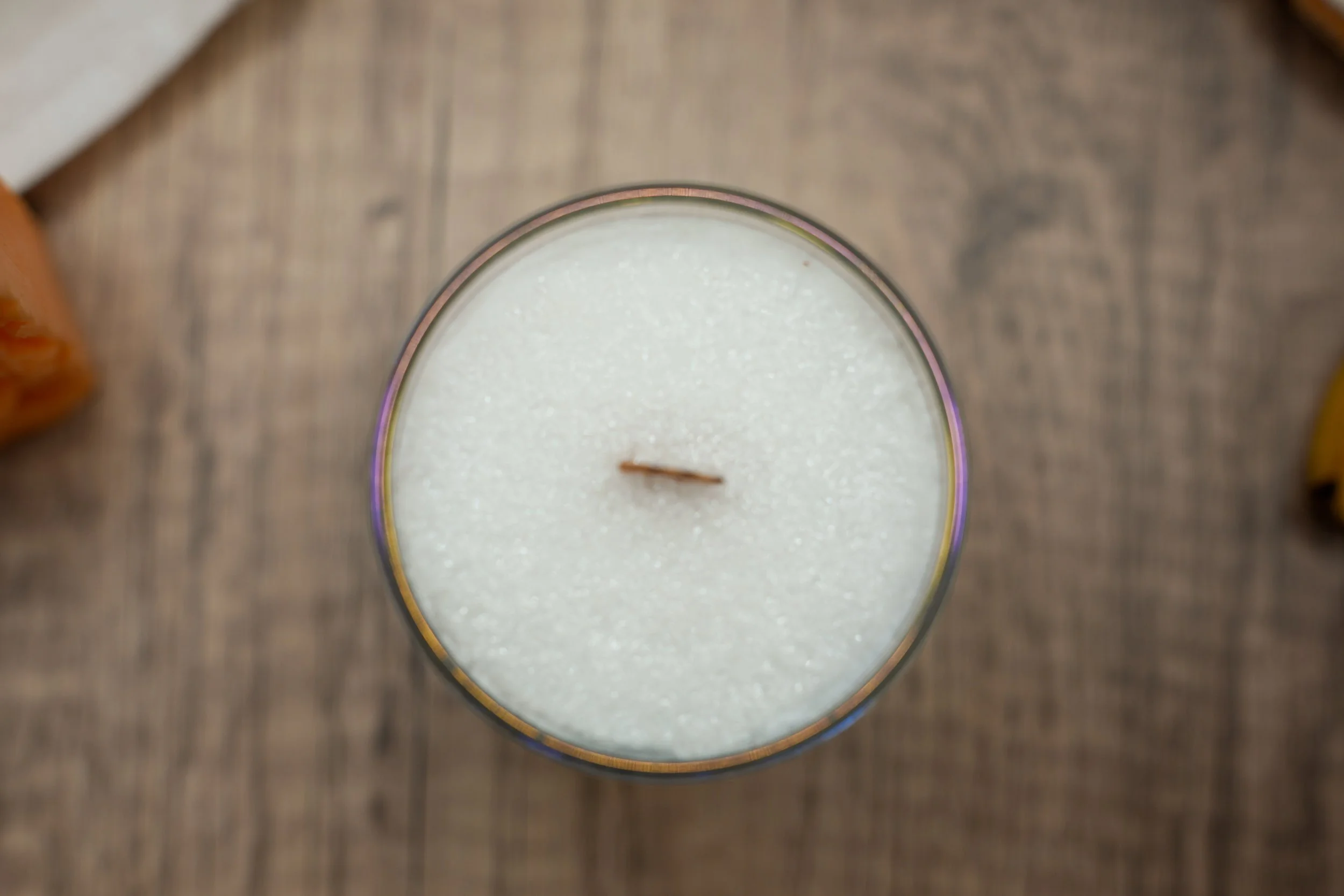 Top view of the 6 oz Butt Naked candle showing its crystalline palm wax and wooden wick in a glass jar.
