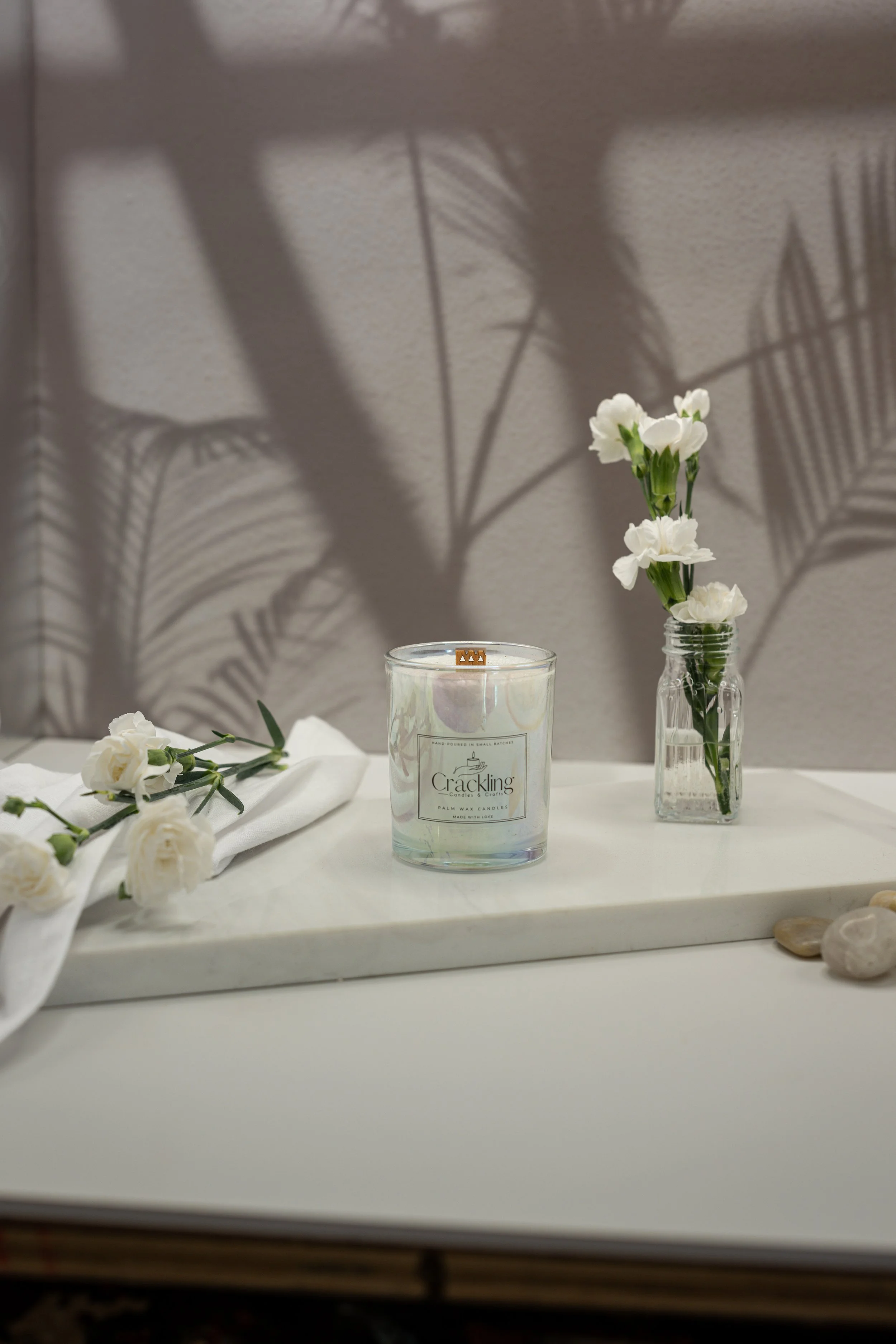Victorian Rose candle displayed with white flowers on a light neutral backdrop