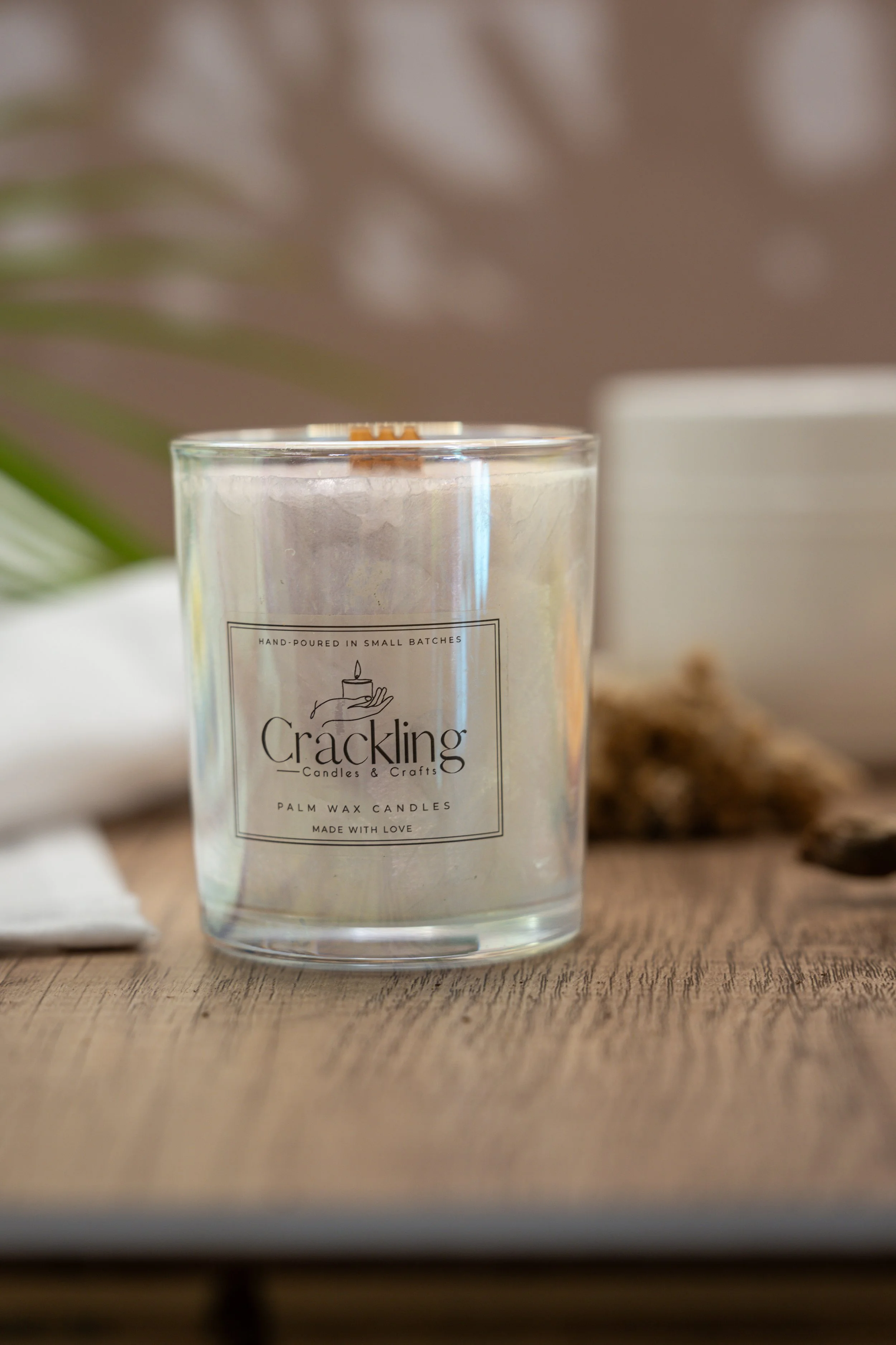 Close-up of a handcrafted Café de Olla candle with a wooden wick, styled beside a white mug on a warm wood surface.