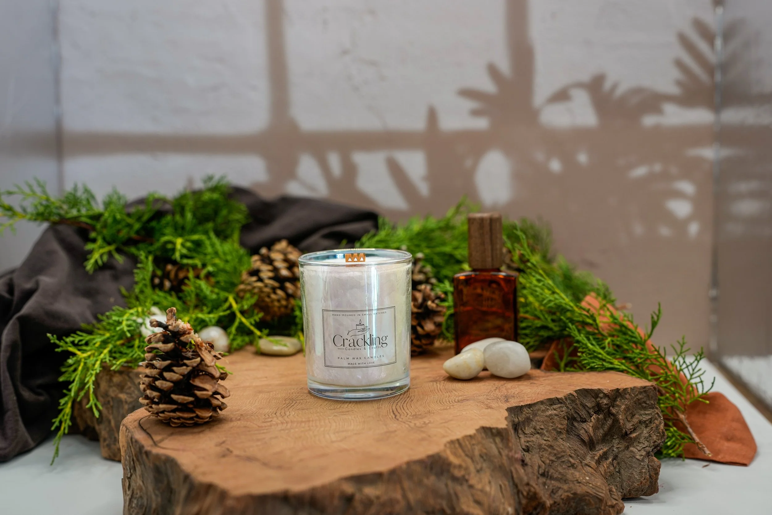 6 oz Cedarwood and Amber palm wax candle with a wooden wick, styled on natural wood with greenery, pinecones, and warm amber decor.