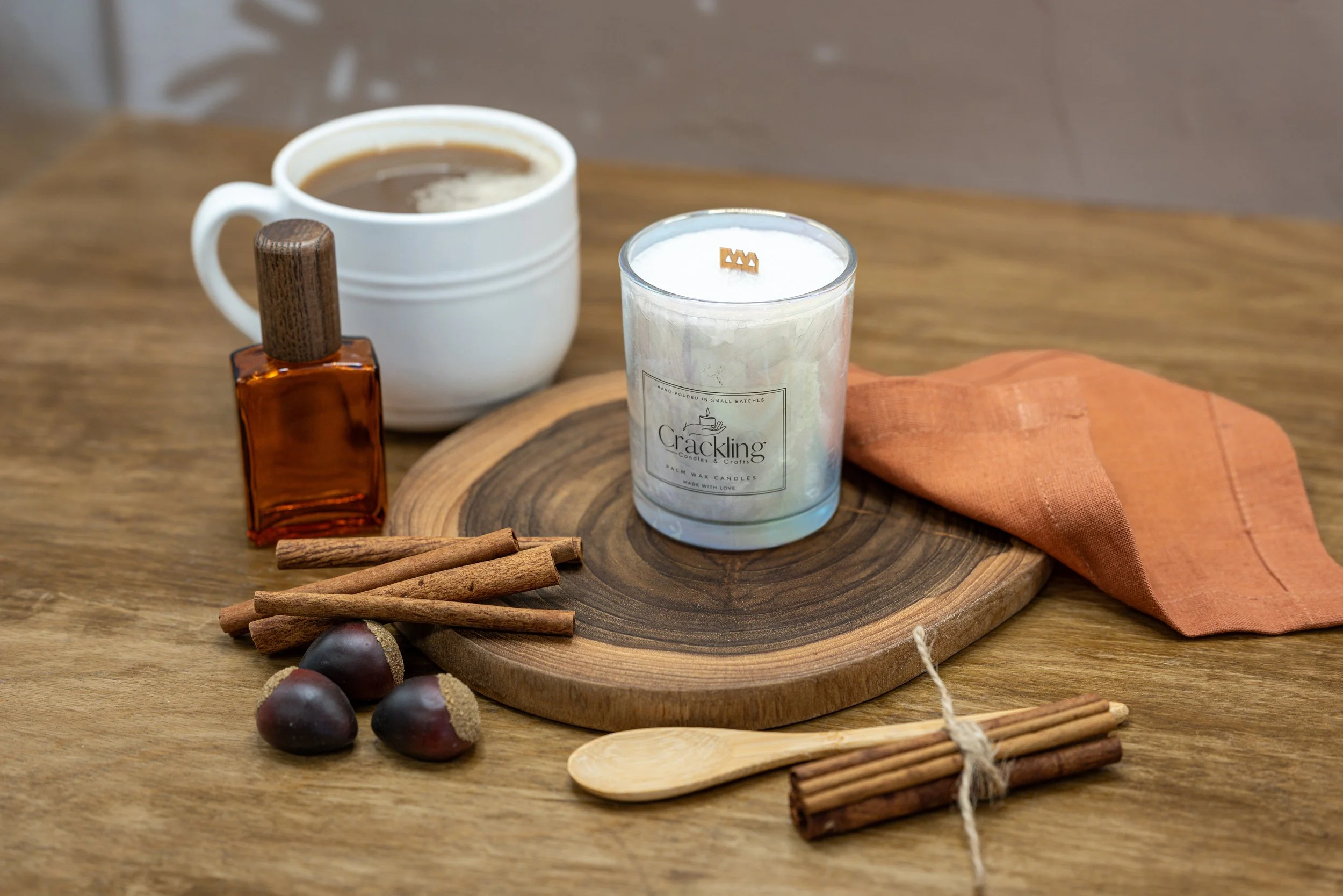 Close view of the 6 oz Hazelnut Cappuccino candle styled with a coffee cup, cinnamon sticks, and hazelnuts
