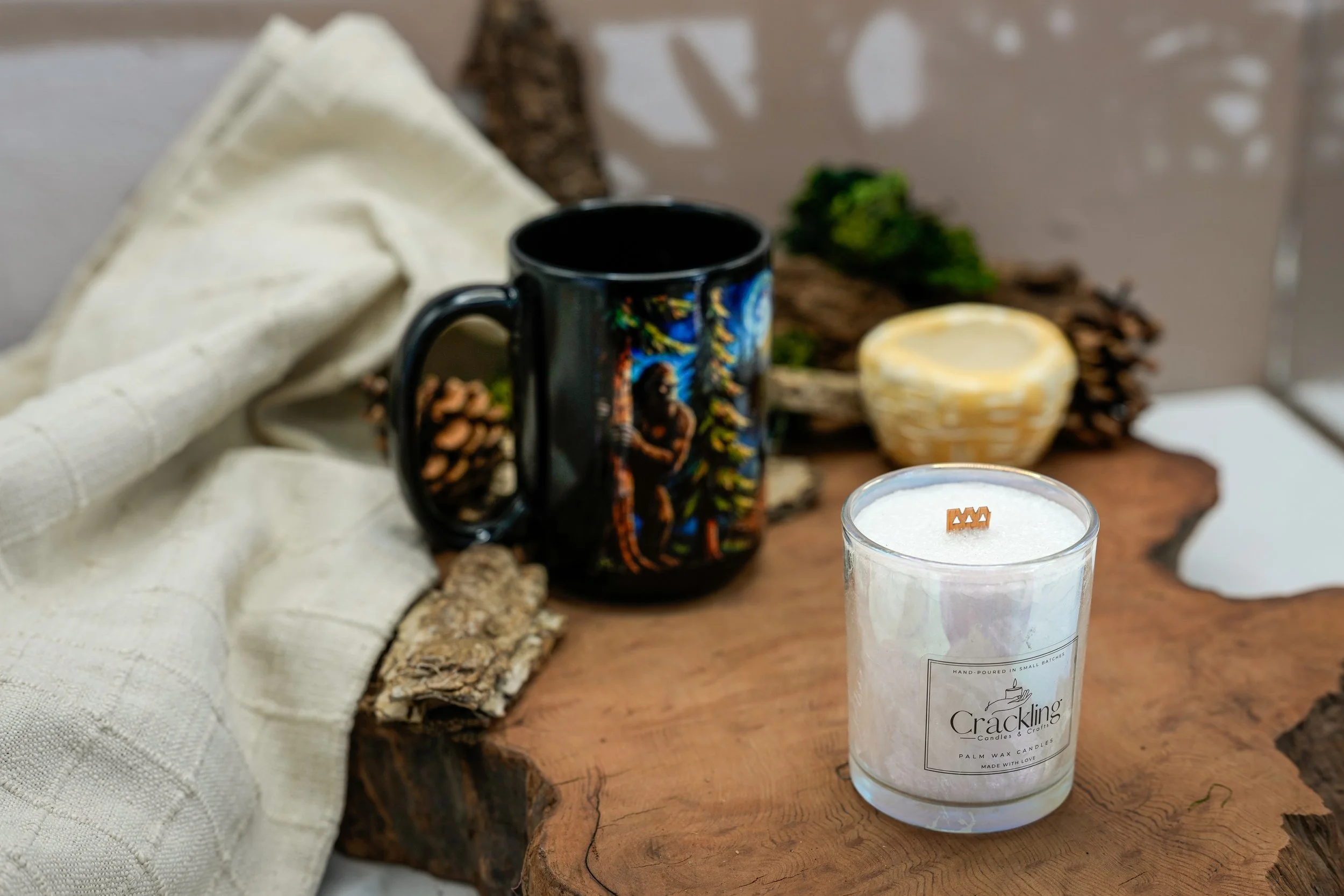 Hand-poured Caribbean Teakwood candle styled with a colorful tropical mug, rustic wood, cream linen, and natural decor.