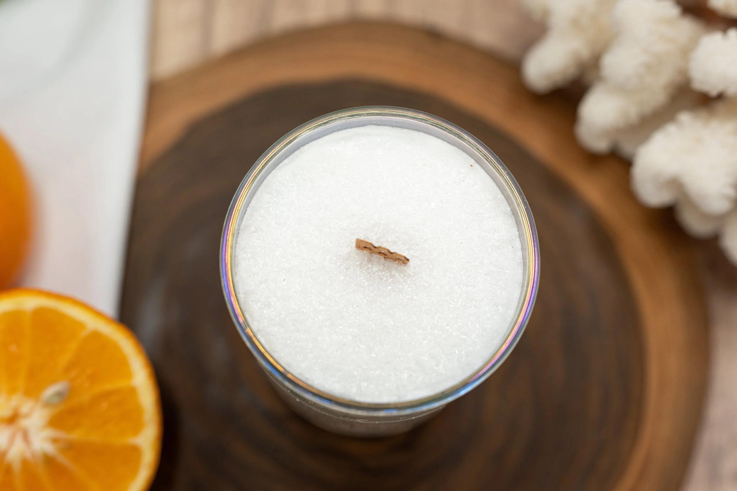 Top view of Orange Goji Berry palm wax candle showing its crystalline wax surface and centered wooden wick.
