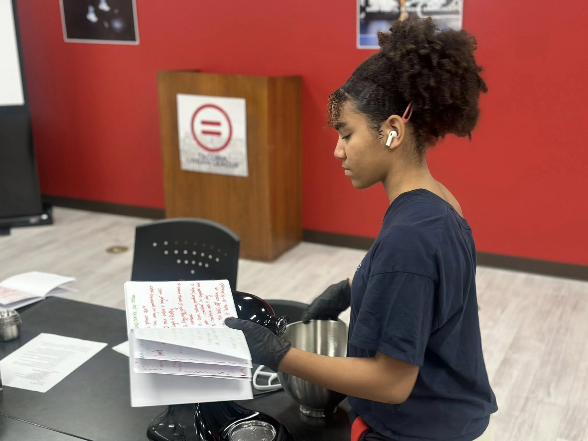 A student writing down recipes at The Junior Bakers Club