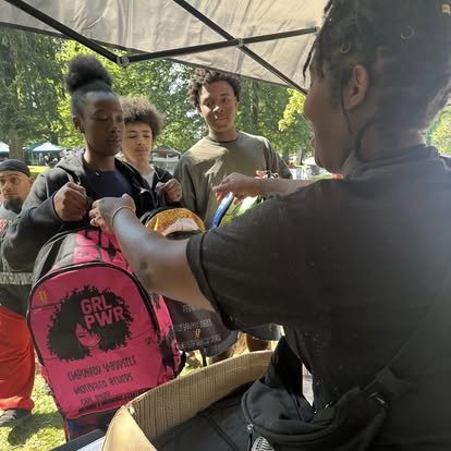 Back To The Bell at Wright park woman handing out a back pack