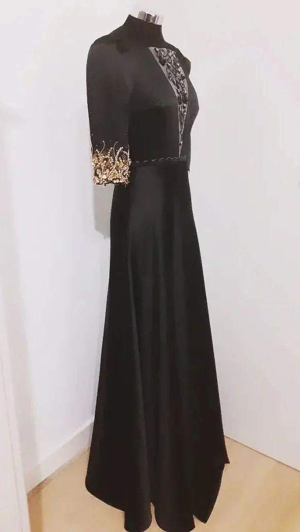 Abito da sera lungo nero con dettagli in oro sulla manica e decorazioni sulla parte superiore