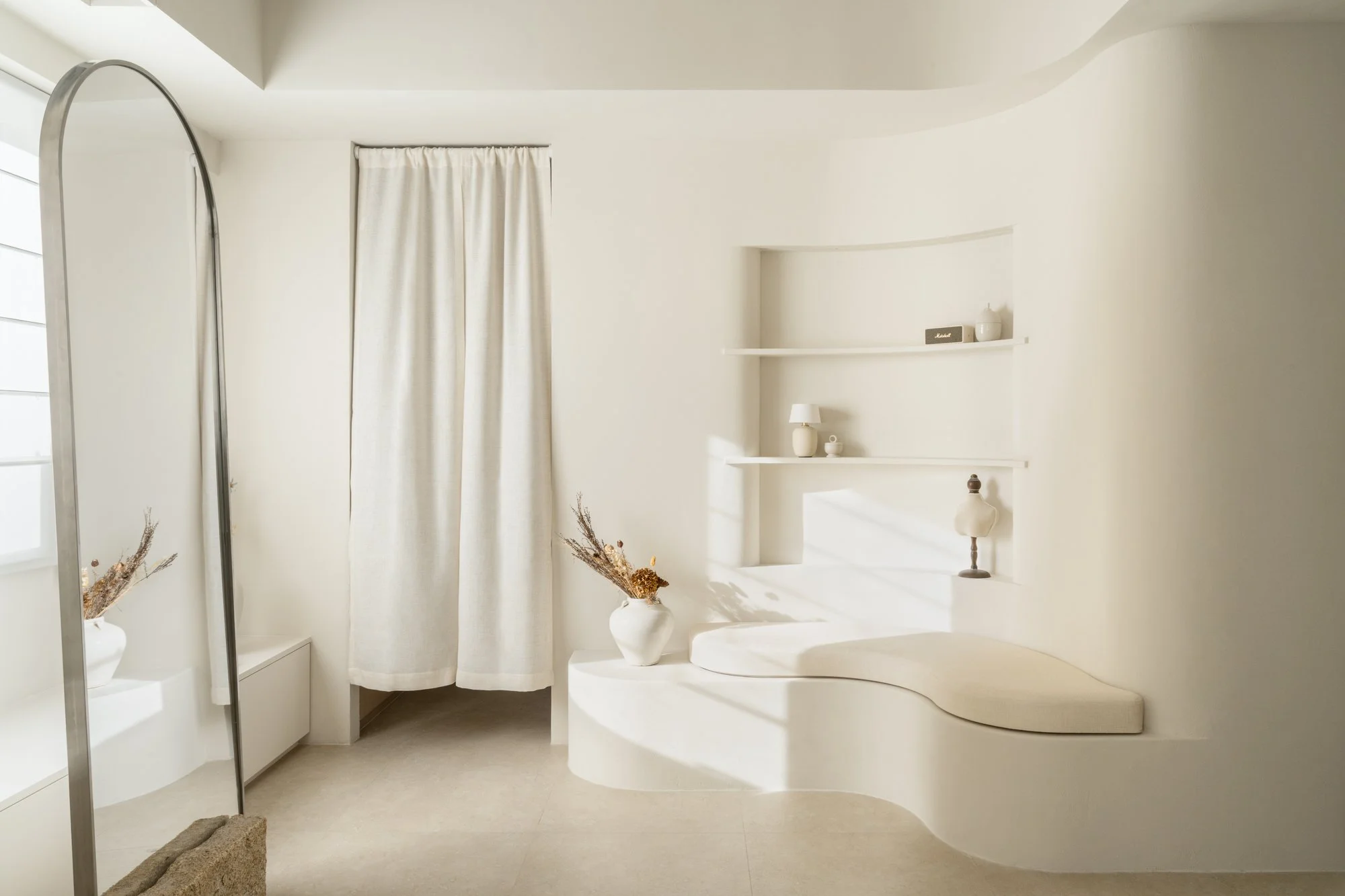 Modern Japandi style with a neutral palette tone, natural stone, arched mirror.Studio using many curves create a more natural sense of flow and softness.