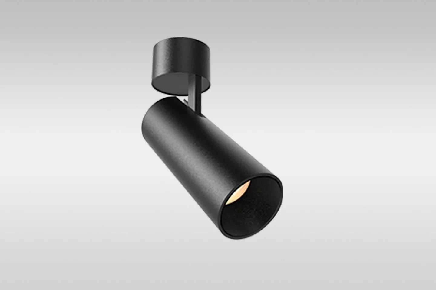 Black spotlight with a cylindrical body mounted on a ceiling or wall