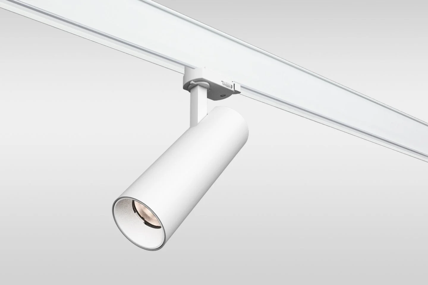 A white adjustable track light fixture attached to a ceiling track.