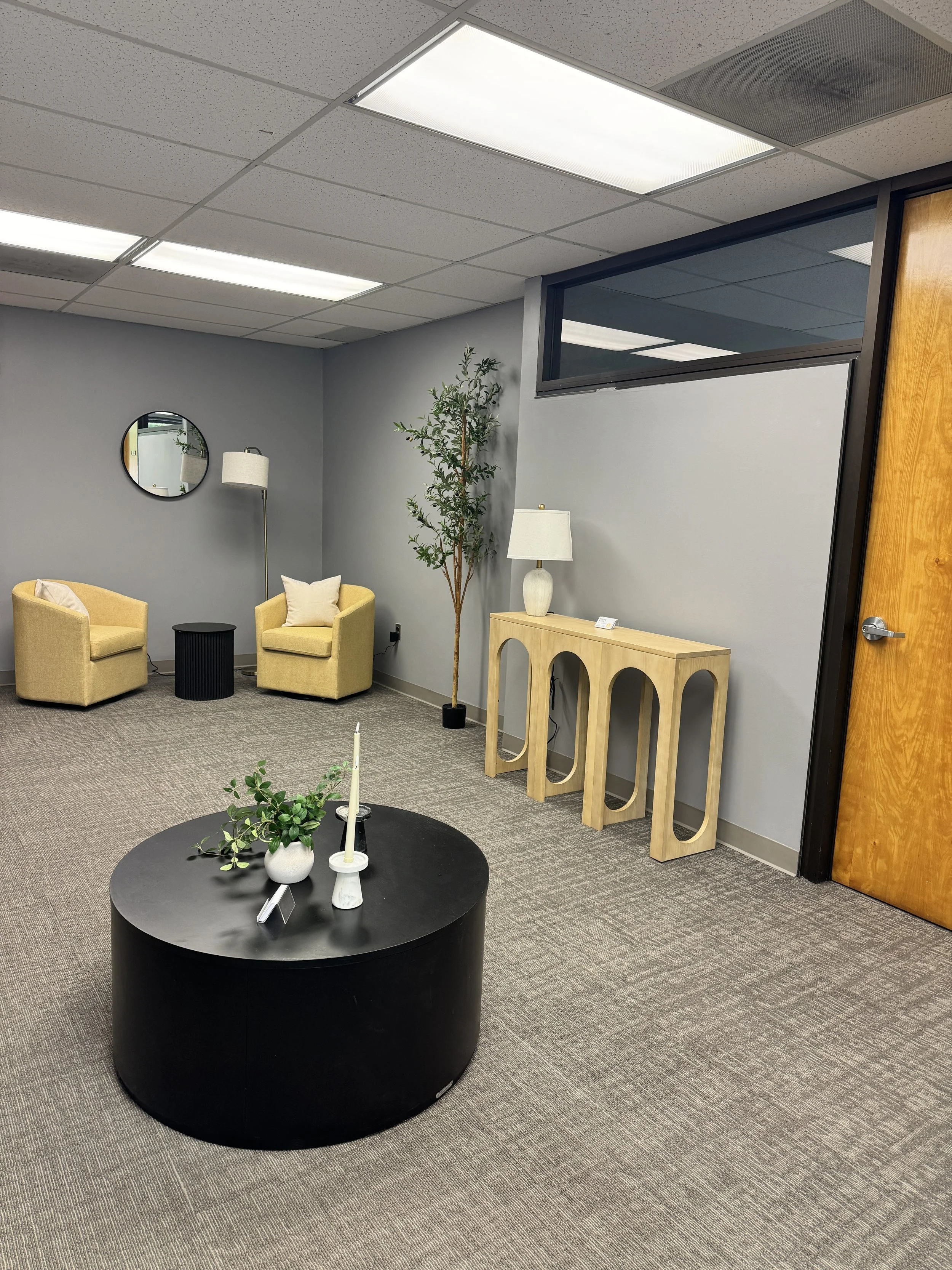 Waiting lounge at the Parsippany couples therapy office with yellow armchairs and an olive tree