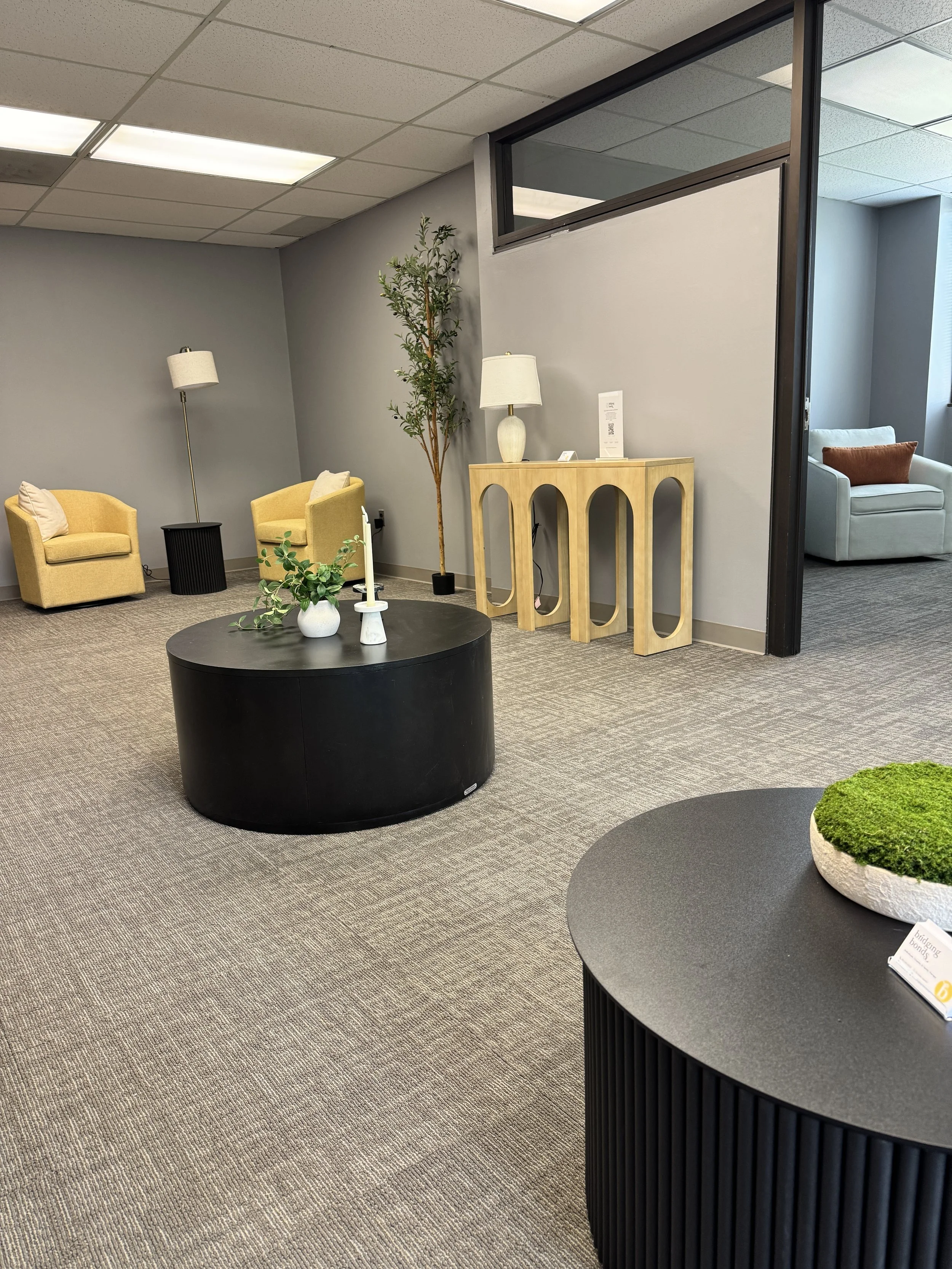 Shared waiting lounge at Bridging Bonds in Parsippany, NJ with yellow armchairs and a round table