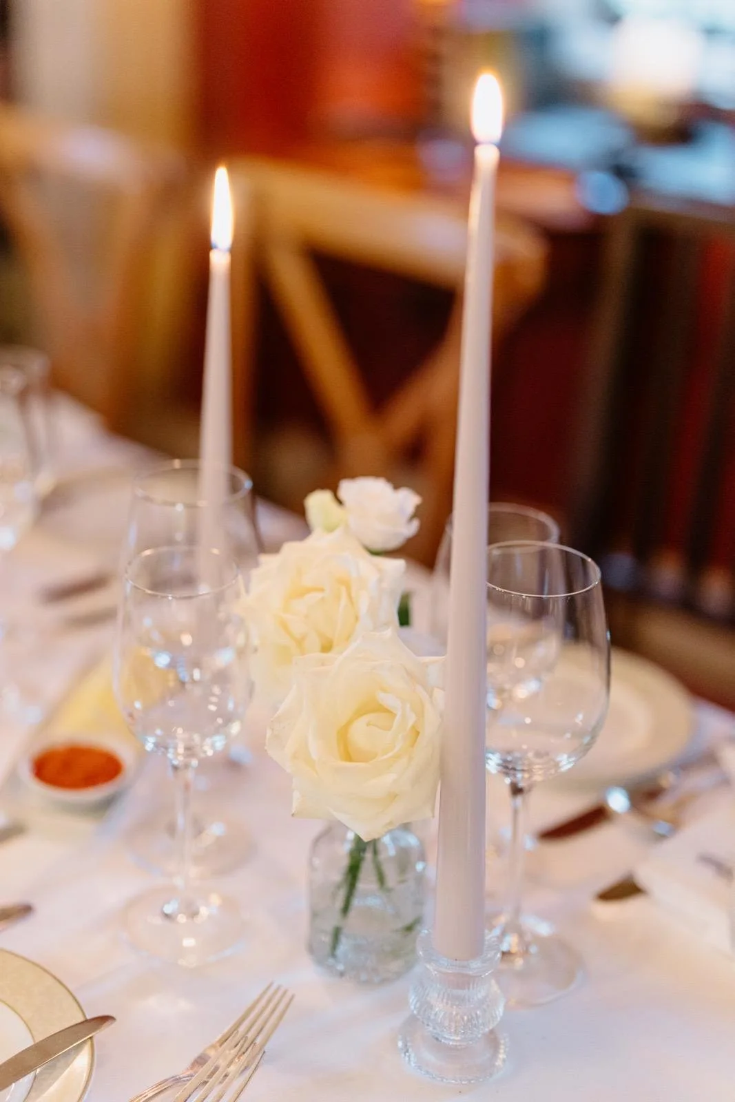 Budvases with white rose and candles wedding flower decor