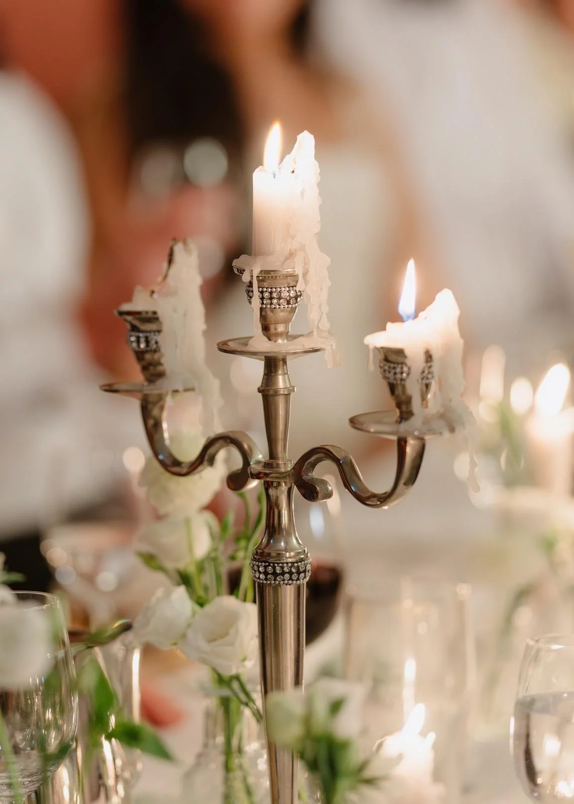 Burning candles on dinner table white and green wedding 