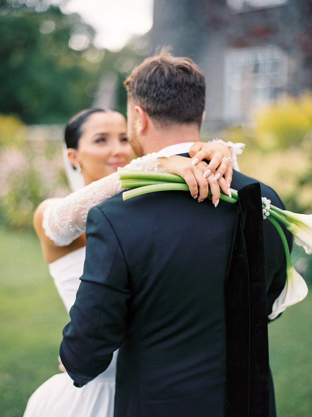 Bride and groom hug wedding flowers