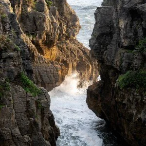Ocean water surging through a rocky coastal inlet.
