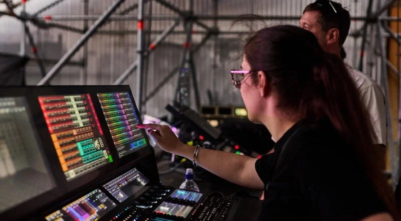 A technician operating an audiovisual control desk.